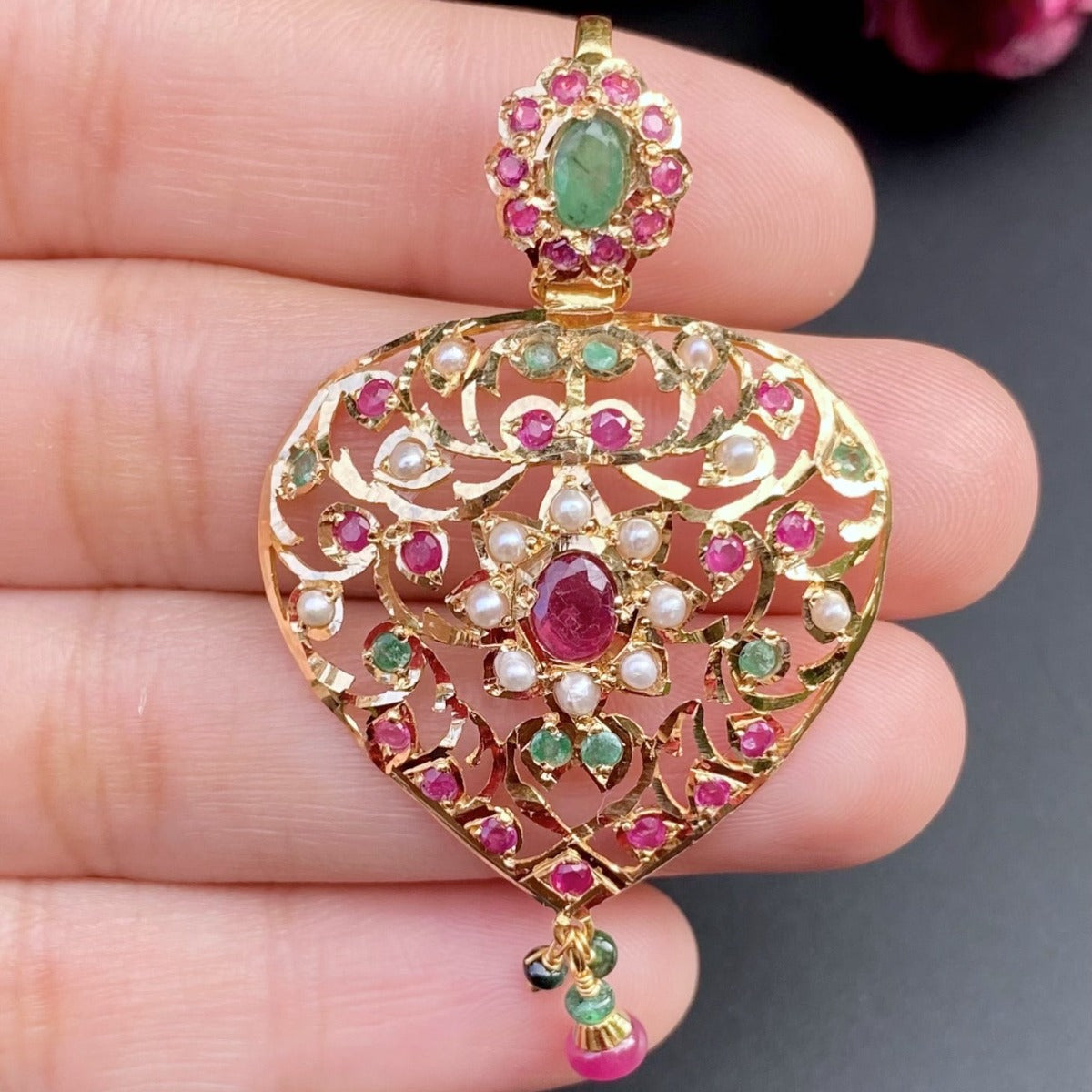 gold pendant set with ruby emerald