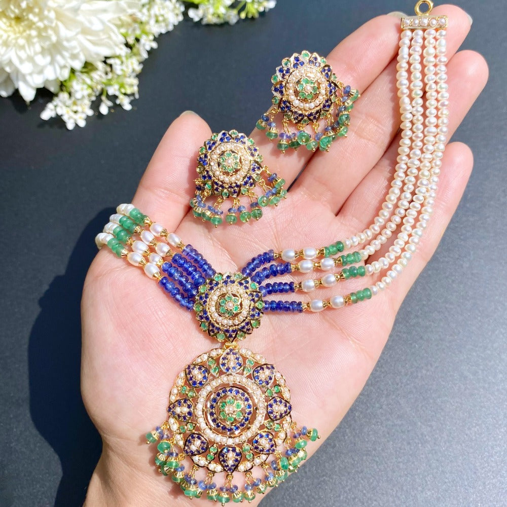 finely handcrafted dainty indian jewelry studded with emeralds pearls and blue sapphire